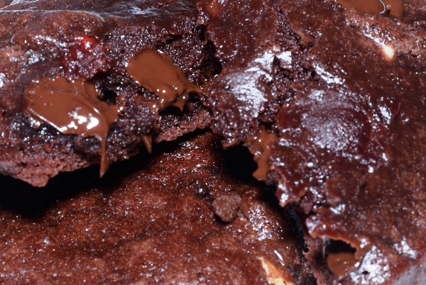 closeup of a cherry chocolate fudge cookie broken in half